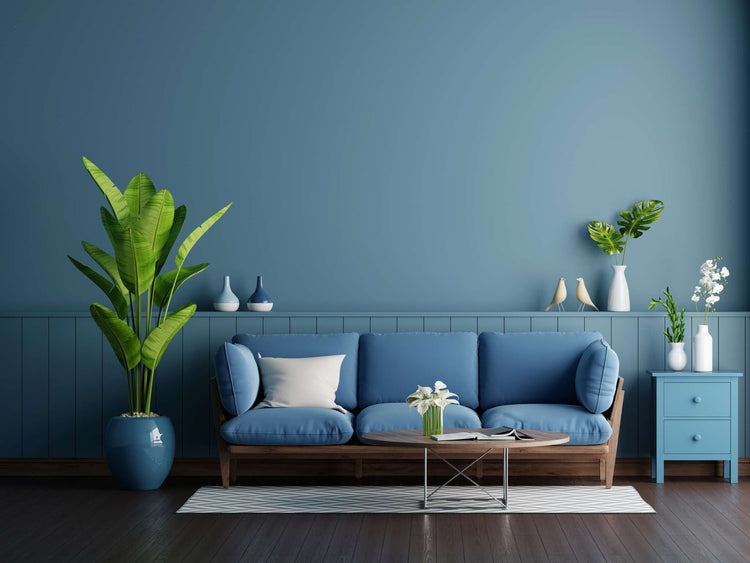 A dark blue-painted dining room wall frames ornate glasses on a table.