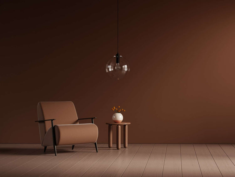 Indoor potted plants beside a sunny window, in front of a brown-painted wall.