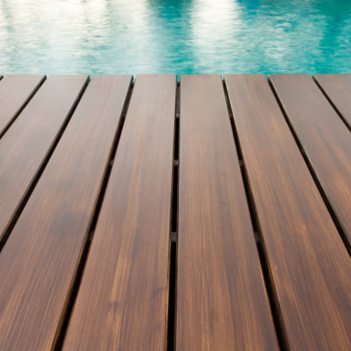 Top down view of striped blue shoes and chair with blue pillow on wooden deck